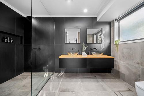 a bathroom with two sinks and a shower at Little Mountain Modern Acreage Retreat in Caloundra West