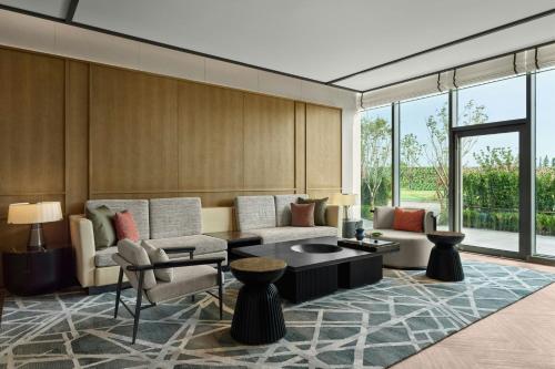 a living room with a couch and a table at Sheraton Kunshan Dianshan Lake in Kunshan