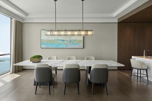 a dining room with a large white table and chairs at Sheraton Kunshan Dianshan Lake in Kunshan