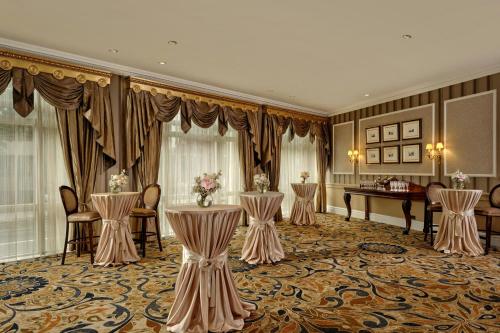 a ballroom with tables and chairs and a piano at The College Green Dublin Hotel, Autograph Collection in Dublin