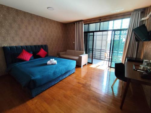 a living room with a blue bed with red pillows at GrabSleepHostel แกร็บสลีปโฮสเทล in Ban Ko