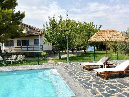 una piscina con dos sillas y una sombrilla en VlLLA PRIVADA - CASA DE MADERA, en Alacón