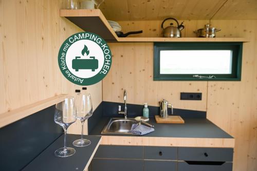 a kitchen with a sink and two wine glasses at Sleep Space 6 - Hooksiel im Wangerland in Wangerland