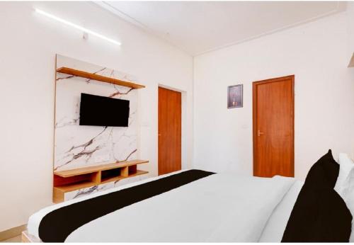 a bedroom with a bed and a tv on a wall at Prem villas homestay in Tājganj
