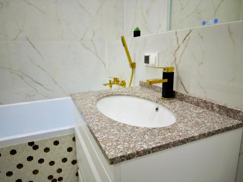een wastafel met een granieten aanrecht bij Royal Boulevard Terrace Residence in Chişinău