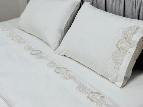 twee witte kussens op het bed bij Royal Boulevard Terrace Residence in Chişinău