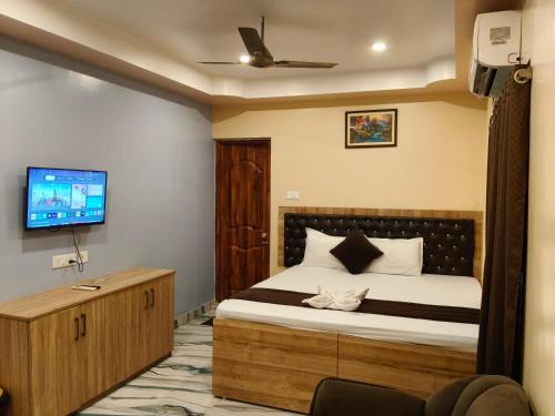 a bedroom with a bed and a flat screen tv at Hotel Mahal in Uchalon