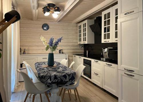 a kitchen with a table with a vase of flowers on it at Шале Біла Ведмедиця in Yablunytsya