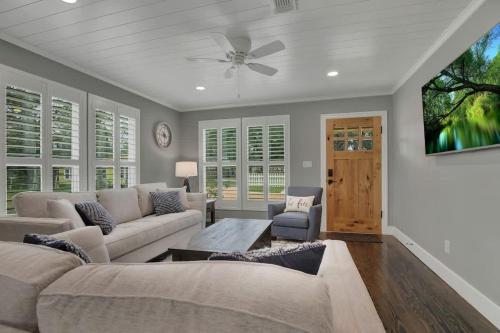 a living room with a couch and a ceiling fan at Upscale Home with Pool and FirePit - Close to Mercer St! in Dripping Springs