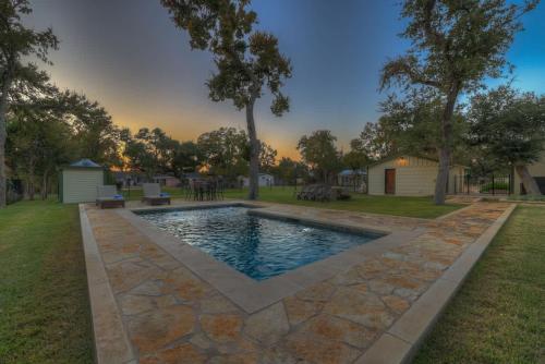 a swimming pool in the middle of a yard at Upscale Home with Pool and FirePit - Close to Mercer St! in Dripping Springs