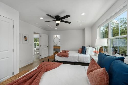 Un dormitorio con una cama y un ventilador de techo. en Rosé Retreat: Luxurious Getaway for 6, Hot Tub, Steps to Main Street, en Fredericksburg