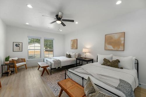 ein Schlafzimmer mit zwei Betten und einem Deckenventilator in der Unterkunft Southern Vine Sip and Stay Combo in Fredericksburg