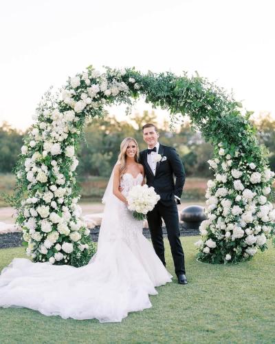 a bride and groom standing under an arch of flowers at Resort at Fredericksburg Unit 28 in Rocky Hill