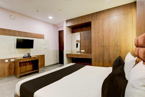 a bedroom with a large bed and a television at Super Hotel O Alipur Narela in New Delhi
