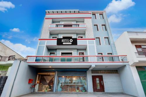 a tall white building with a sign on it at Super Hotel O Alipur Narela in New Delhi