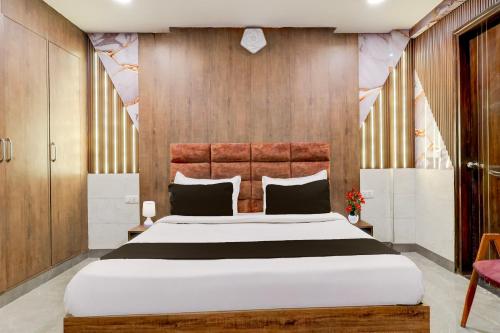 a bedroom with a large bed and wooden walls at Super Hotel O Alipur Narela in New Delhi