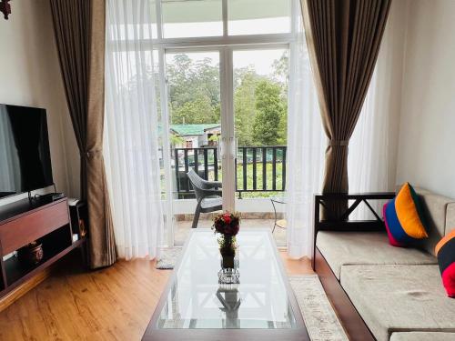 a living room with a couch and a glass table at Galway Green - Lake View Luxury Apartment, Nuwara Eliya Sri Lanka in Nuwara Eliya