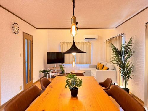 a living room with a wooden table and a couch at OKA Stay OKAYAMA in Okayama