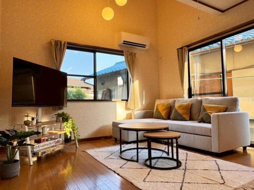a living room with a couch and a table at OKA Stay OKAYAMA in Okayama