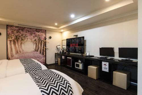 a hotel room with a bed and a tv at 캠프관광호텔 in Seoul