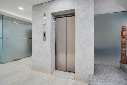 a elevator lobby with a metal door in a building at Super Townhouse Sector 63 A Noida in Noida