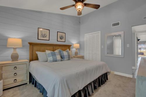 Un dormitorio con una cama y un ventilador de techo. en Fisherman Friend! - Coastal Condo - Views Await!, en Fulton