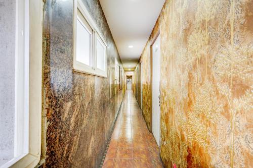 a corridor of an old building with rusty walls and a window at Super Hotel O Vadapalani Metro Station Chennai Formerly Vishnu's Galaxy Rooms in Chennai