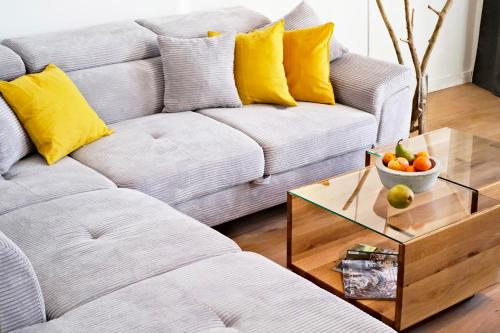 a living room with a couch and a table with a bowl of fruit at Aesten Mare Kühlungsborn Apartment 2 in Kühlungsborn