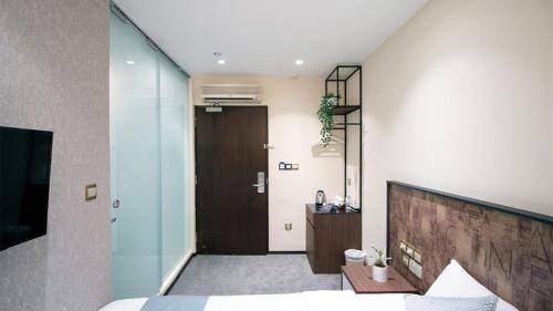 a bedroom with a bed and a sliding door at Hotel Calmo Hamilton in Singapore