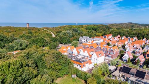 an aerial view of a town with orange roofs at Duinhof Klein Dishoek - Appartementen onder aan de duinen, in het centrum met terras in Dishoek