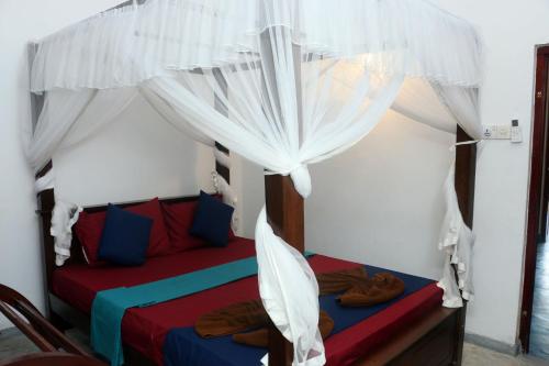 a bedroom with a bed with a canopy at Blue Sky in Mirissa