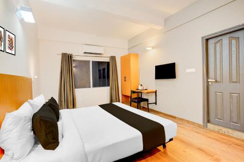 a hotel room with a bed and a window at Super Townhouse HAL Indiranagar Extension in Bengaluru