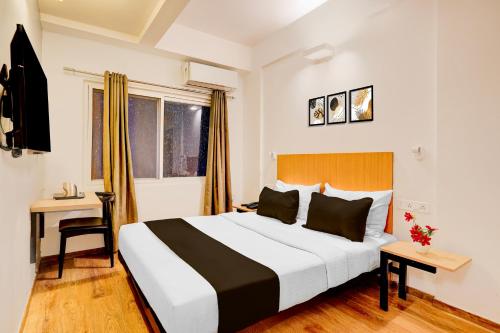 a hotel room with a large bed and a desk at Super Townhouse HAL Indiranagar Extension in Bengaluru