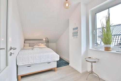 a small bedroom with a bed and a window at Haus Oberdeck 2 in Scharbeutz