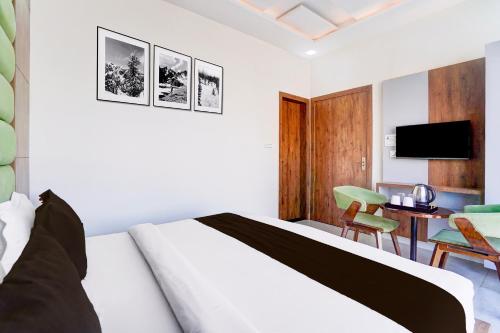 GovardhanにあるTownhouse Govardhanのベッド、机、テレビのある寝室