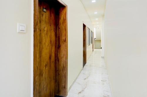 a hallway with a wooden door and a marble floor at Townhouse Govardhan in Govardhan