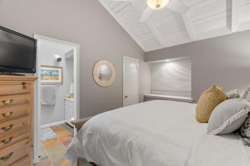 a bedroom with a white bed and a flat screen tv at Lakeside condo Retreat in Horseshoe Bay in Horseshoe Bay