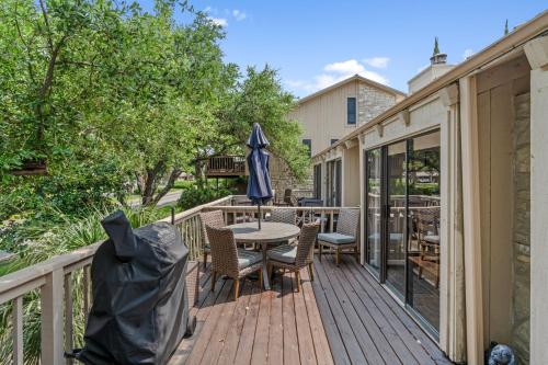 a deck with a table and chairs and an umbrella at Lakeside condo Retreat in Horseshoe Bay in Horseshoe Bay