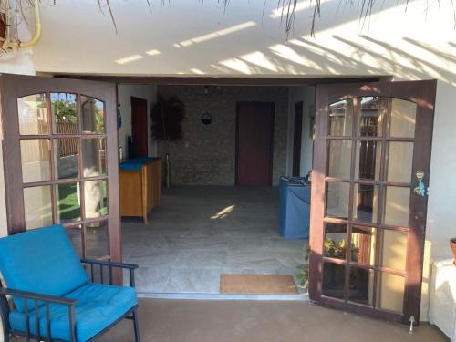 an open door of a house with a blue chair at Savaneta house in Savaneta