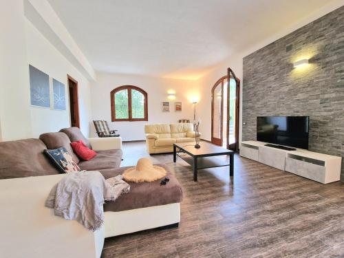 a living room with a couch and a television at Villa Giacoma hot tub and garden in Mandra Capreria