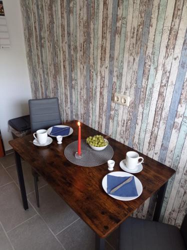 a wooden table with a candle and a plate with at Haus Morgenstern Fewo Ünnern in Neuharlingersiel