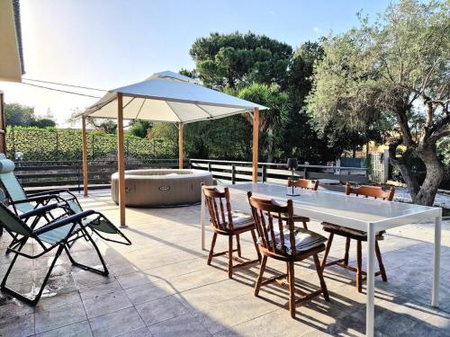 a table and chairs and an umbrella on a patio at Villa Giacoma hot tub and garden in Mandra Capreria
