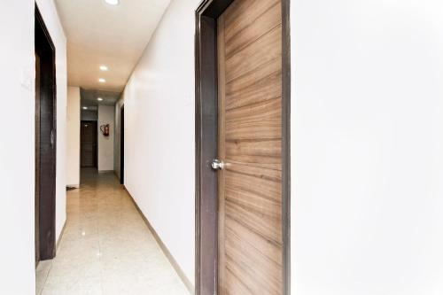 a hallway with a wooden door in a house at Super Hotel O Tagore Park Laskarhat formerly Shankar Guest House in Kolkata