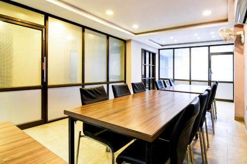 a conference room with a wooden table and chairs at Super Hotel O Tagore Park Laskarhat formerly Shankar Guest House in Kolkata