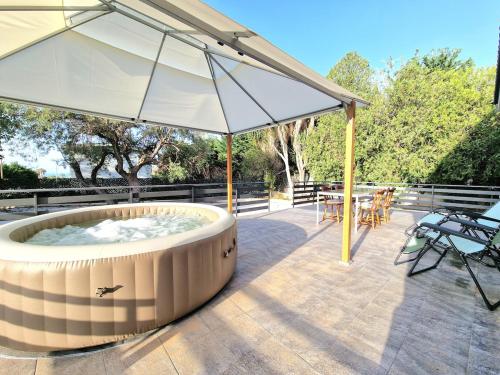a large umbrella over a hot tub on a patio at Villa Giacoma hot tub and garden in Mandra Capreria