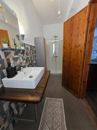 a bathroom with a white sink and a wooden cabinet at Villa Giacoma hot tub and garden in Mandra Capreria