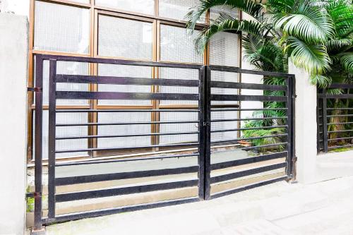 a black gate on a building with windows at Super Hotel O Tagore Park Laskarhat formerly Shankar Guest House in Kolkata