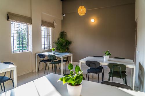 a restaurant with two tables and chairs and plants at Olive Hotel Millers Road by Embassy Group in Bengaluru