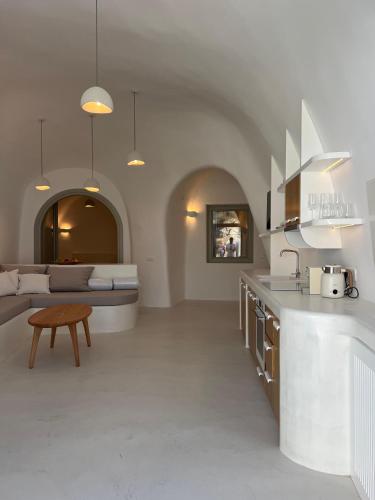 a kitchen and living room with a couch and a table at EG Cave Houses in Éxo Goniá