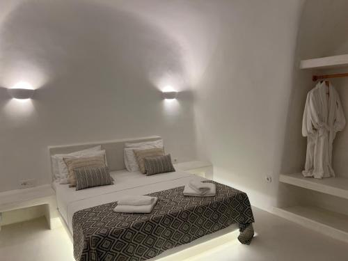 a white bedroom with a bed with towels on it at EG Cave Houses in Éxo Goniá